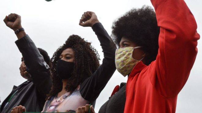 Grupo de amigos negros entrega bandeira nova à equipe de segurança do Palácio Iguaçu para protestar contra vândalos que queimaram a bandeira dois dias antes a título de protestar contra o racismo