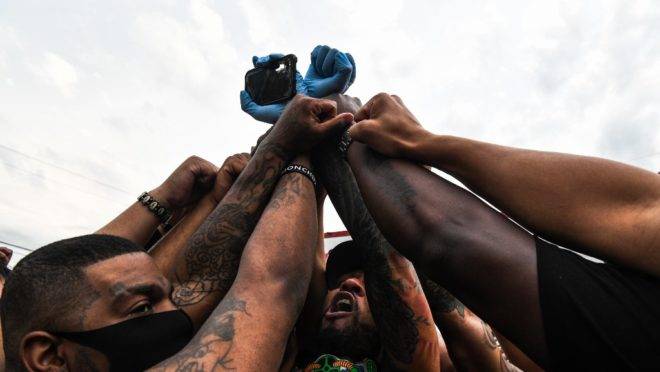 Pessoas erguem os punhos e se ajoelham em protesto pela morte de George Floyd em Minneapolis, 2 de junho de 2020