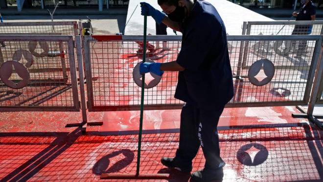 Funcionário limpa tinta vermelha que foi jogada por manifestante em frente ao Palácio do Planalto