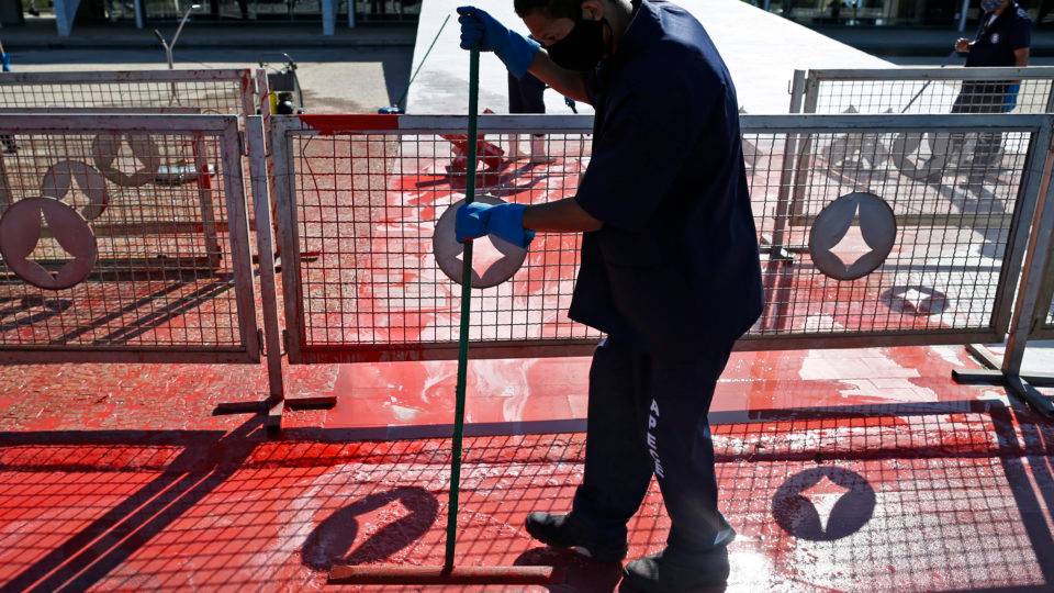 Funcionário limpa tinta vermelha que foi jogada por manifestante em frente ao Palácio do Planalto