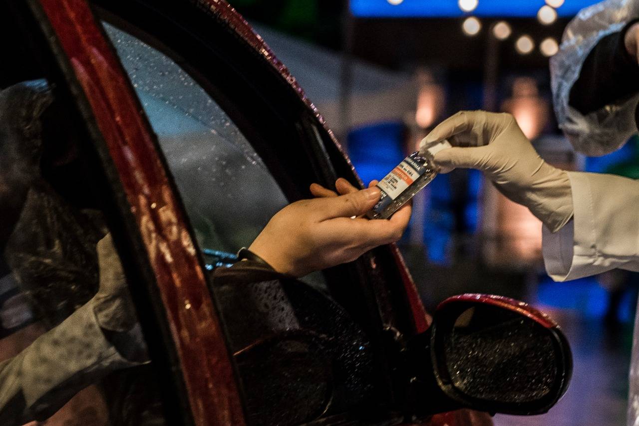 Cada carro recebe um fraco de álcool em gel ao entrar no cine drive-in. Foto: Letícia Akemi Cada carro recebe um fraco de álcool em gel ao entrar no cine drive-in. Foto: Letícia Akemi