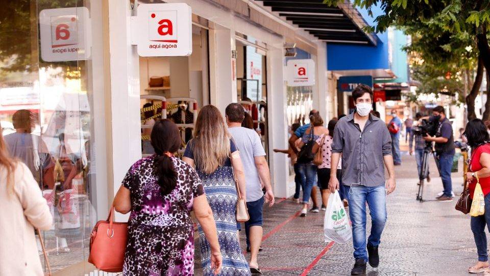 Cada dia sem distanciamento social alonga surto da Covid em 2,4 dias, diz estudo Transeuntes em rua comercial de Maringá