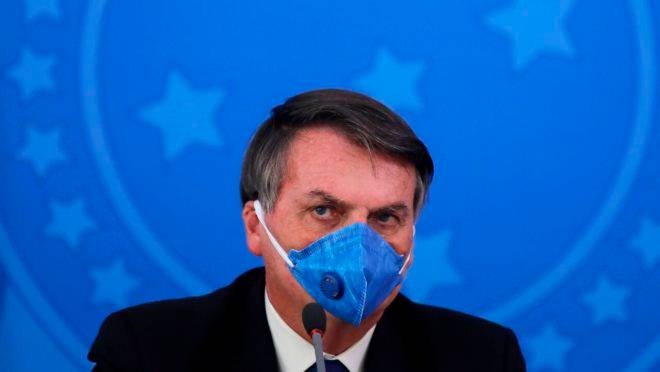Nesta foto de arquivo tirada em 20 de março de 2020, o presidente do Brasil, Jair Bolsonaro, usa máscara facial durante uma conferência de imprensa sobre a pandemia de coronavírus COVID-19 no Palácio do Planalto, em Brasília.