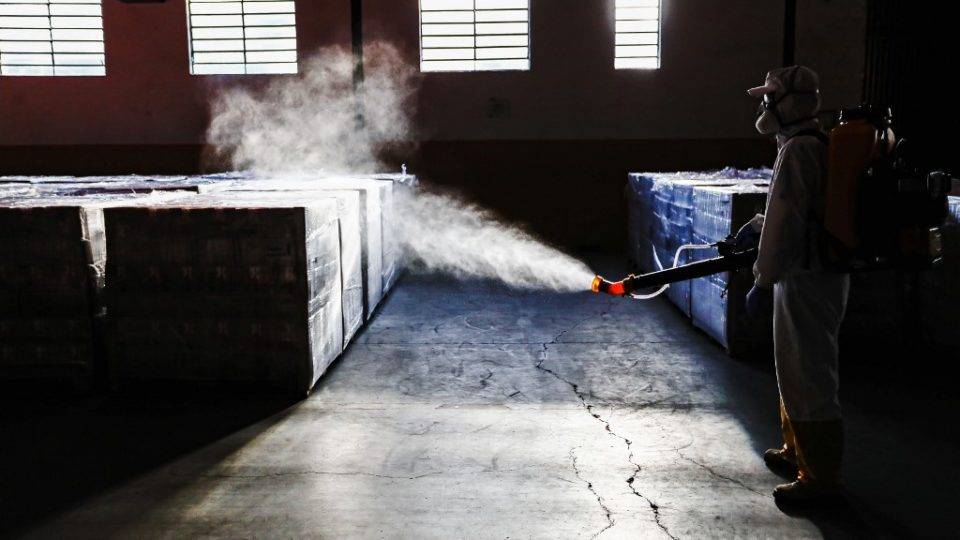 O difícil caminho de retorno à normalidade Um trabalhador desinfeta suprimentos em um armazém municipal em Curitiba, em 19 de junho de 2020.
