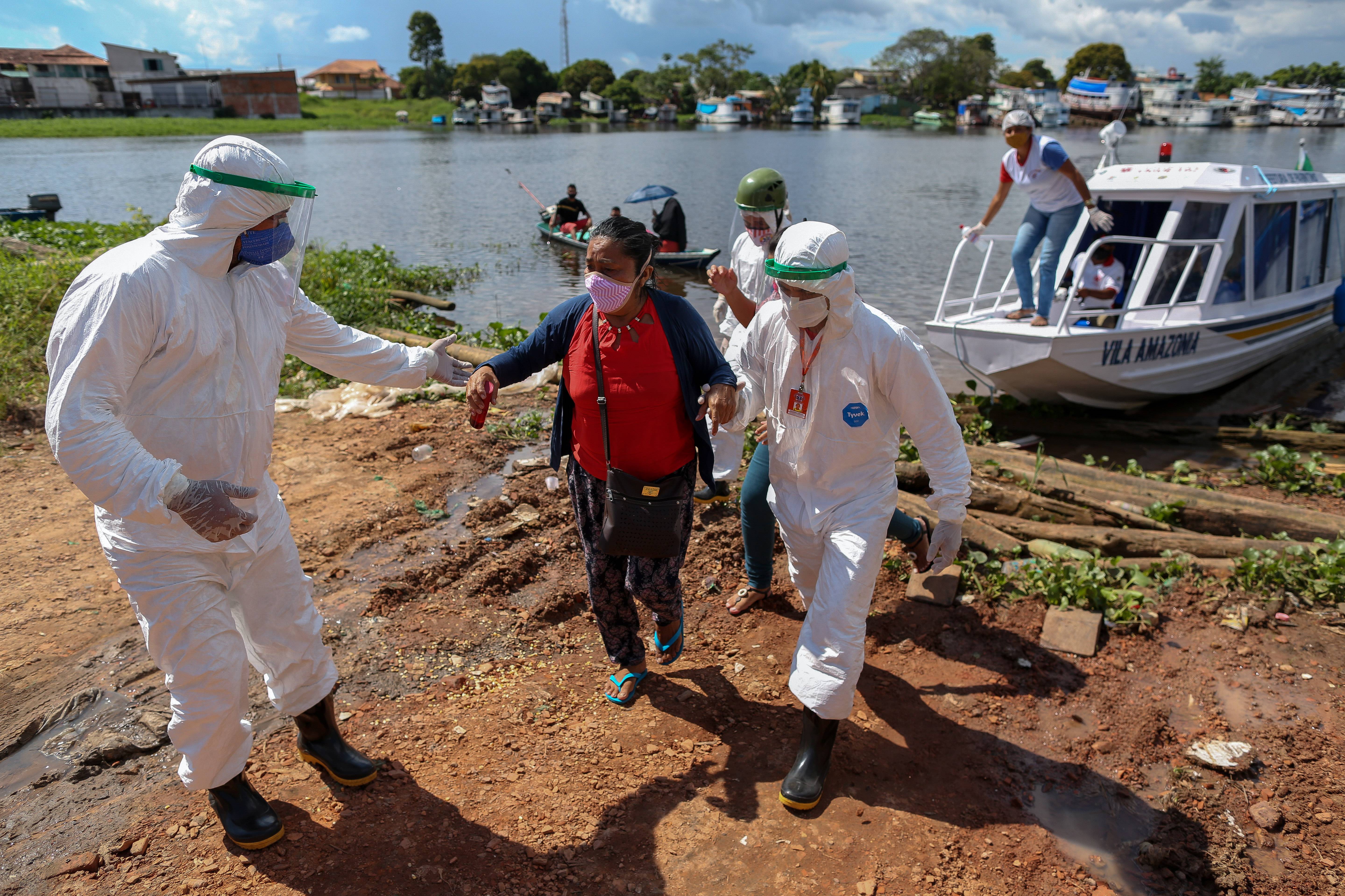 Profissionais de saúde ajudam pacientes com sintomas da Covid-19 em "barco-ambulância", em Parintins, no Amazonas
