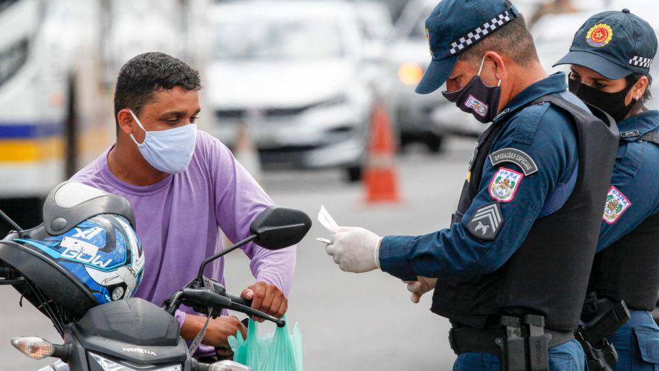 Lockdown pelo Brasil: o que a experiência em outros estados mostra ao Paraná? Policial militar faz inspeção de documentos de motoqueiro em Belém do Pará, durante vigência do lockdown que restringiu a circulação de pessoas nas ruas.