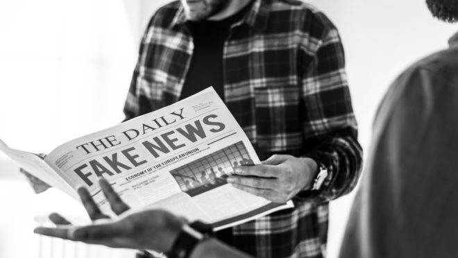 Men reading newspaper isolated on white background