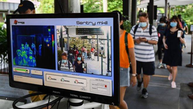 Cidadãos de Singapura têm a temperatura medida eletronicamente: uso intensivo da tecnologia está por trás do sucesso de países asiáticos na contenção do novo coronavírus.