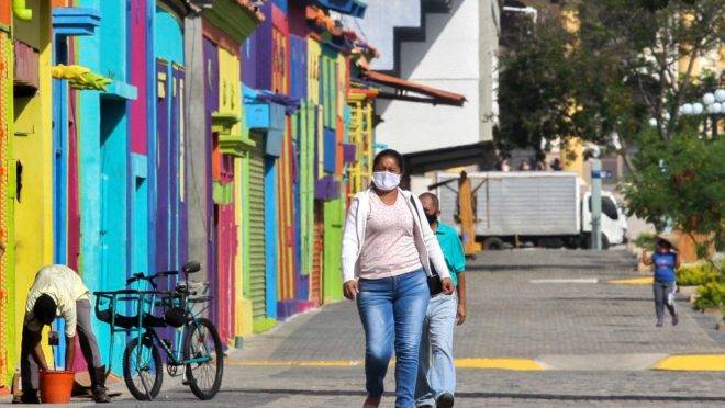 Pessoas usando máscara de proteção caminham pelas ruas de Maracaibo, segunda maior cidade da Venezuela (Luis Bravo/AFP).