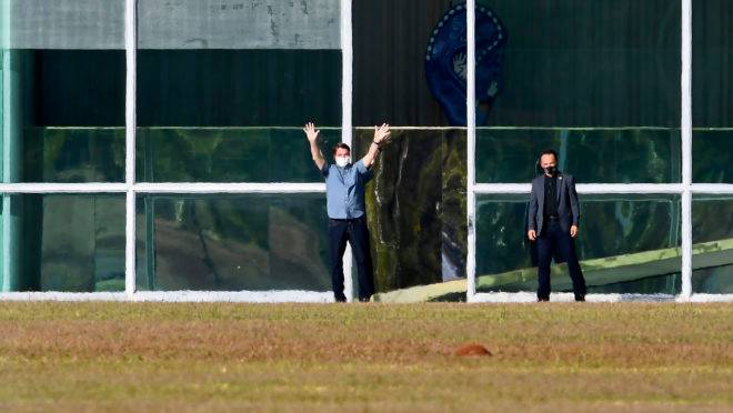 O presidente Bolsonaro caminhando do lado de fora do Palácio do Alvorada, em foto de 9 de julho: com diagnóstico de Covid-19, presidente tem permanecido na residência oficial.