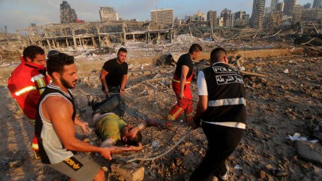 Bombeiros carregam homem ferido em local perto de onde ocorreram as explosões em Beirute em 4 de agosto de 2020.
