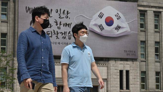 Pedestres usam máscara nas ruas de Seul, Coreia do Sul.