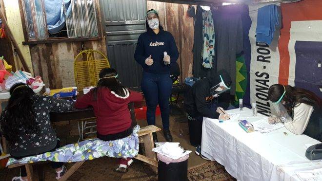 A líder comunitária da favela Primeiro de Maio, no bairro Cidade Industrial de Curitiba, recebe crianças na garagem de casa para ajudar nas tarefas escolares.