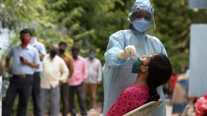 Médicos residentes realizam testes de Covid-19 na cidade de Hyderabad, no Sul da Índia.
