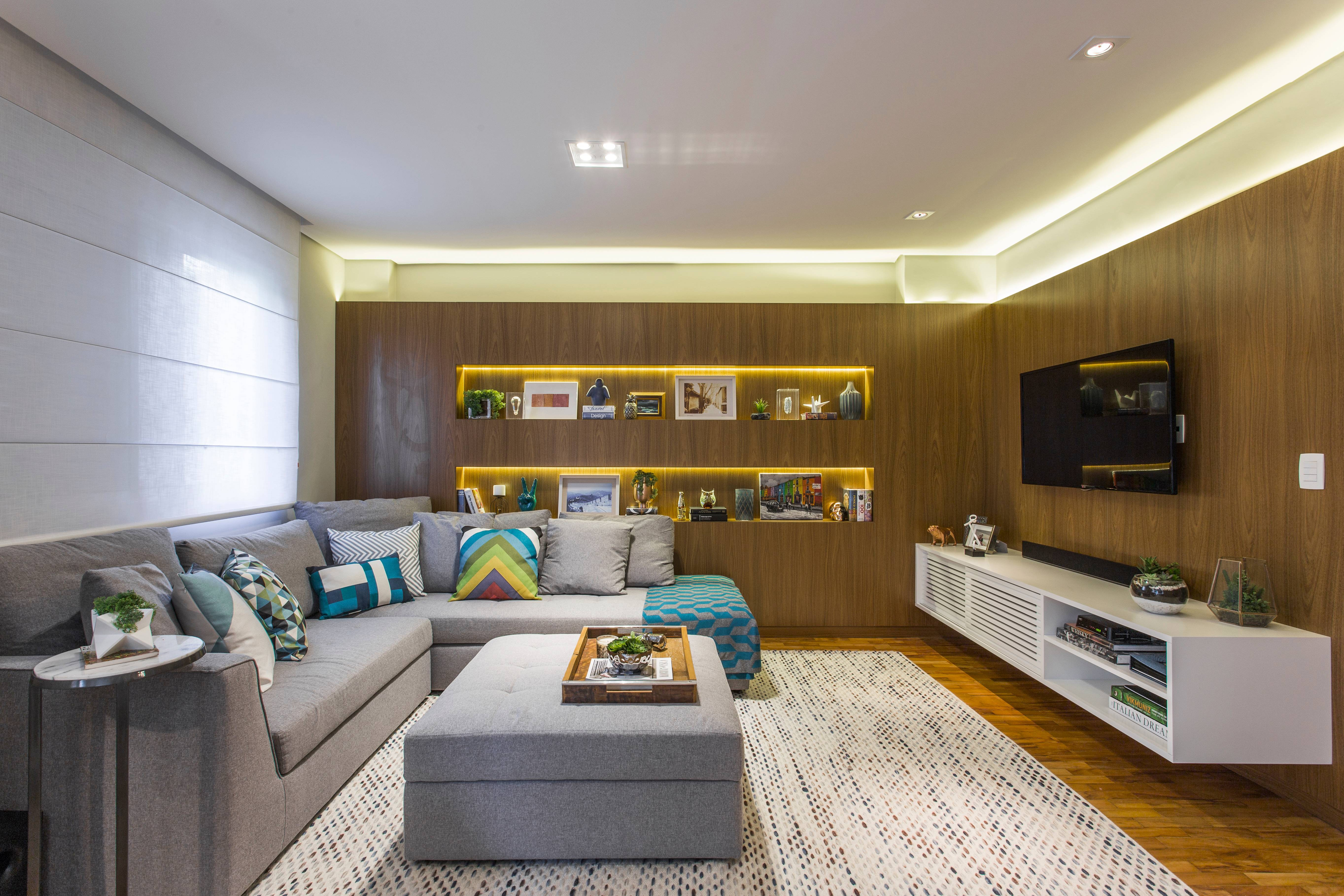 A decoração do home theater equilibra itens com estampas geométricas, turquesa e nichos iluminados por fitas de LED. Em L, o sofá otimiza o ambiente e é bem confortável para ver TV. A decoração do home theater equilibra itens com estampas geométricas, turquesa e nichos iluminados por fitas de LED. Em L, o sofá otimiza o ambiente e é bem confortável para ver TV.