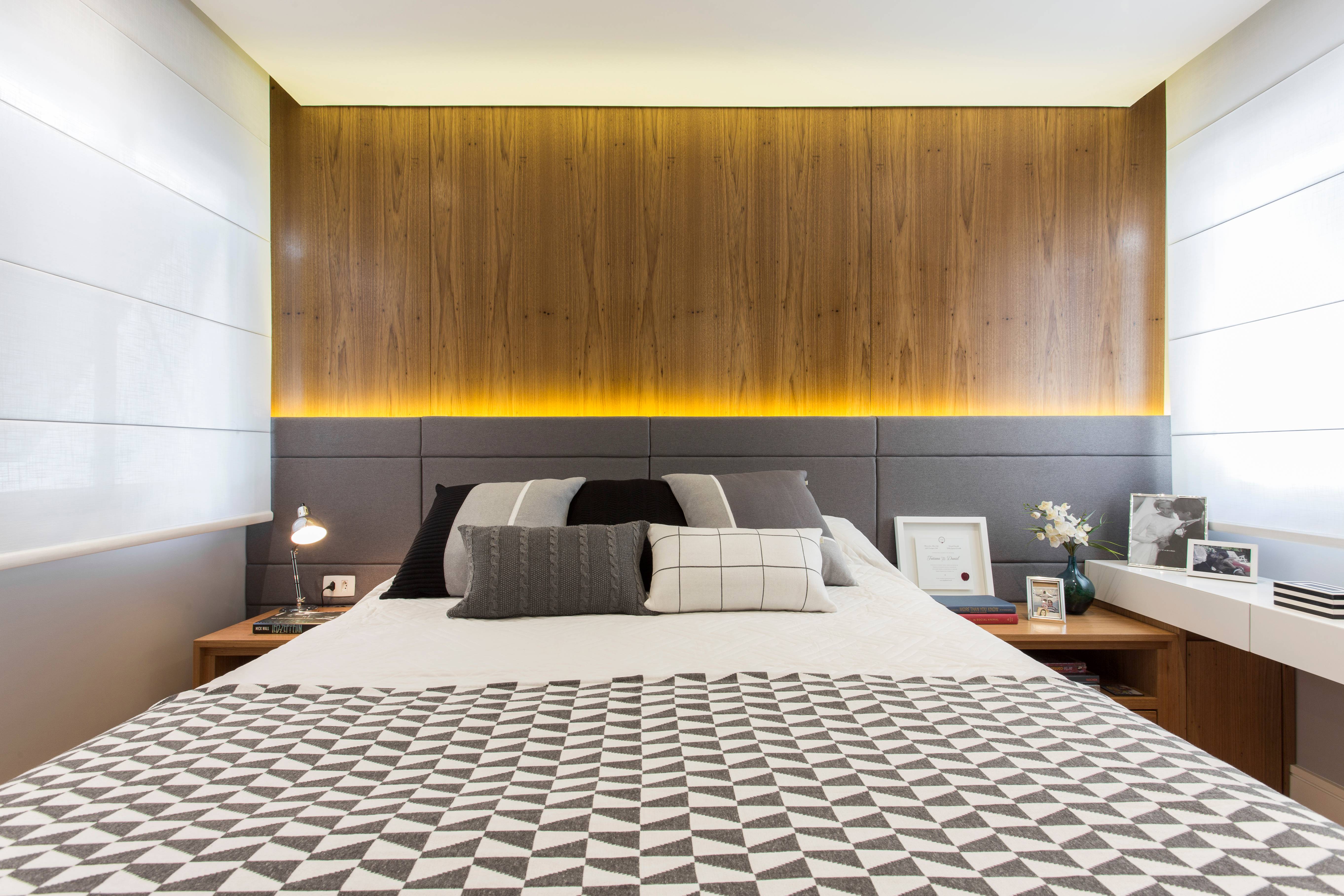 Para o quarto do casal, a proposta foi trazer um painel de madeira freijó, assim como uma cabeceira estofada, iluminada com fita de LED. O móvel sob medida aproveita o espaço sob a janela para abrigar uma penteadeira. Para o quarto do casal, a proposta foi trazer um painel de madeira freijó, assim como uma cabeceira estofada, iluminada com fita de LED. O móvel sob medida aproveita o espaço sob a janela para abrigar uma penteadeira.