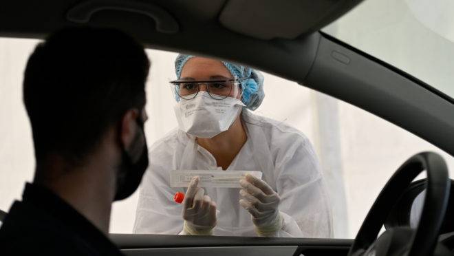 A health official collects a nasal swab sample from a man for a Covid-19 coronavirus test in a “Covid Drive” at the University Hospital Center (CHU) in Rennes, western France, on September 7, 2020. (Photo by Damien MEYER / AFP)