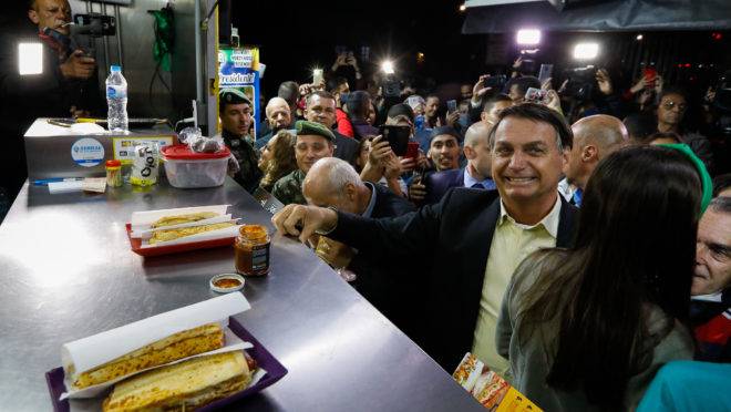 Presidente Jair Bolsonaro para para comer cachorro quente durante vista à Academia Militar das Agulhas Negras, em Resende (RJ), na quarta-feira (23).