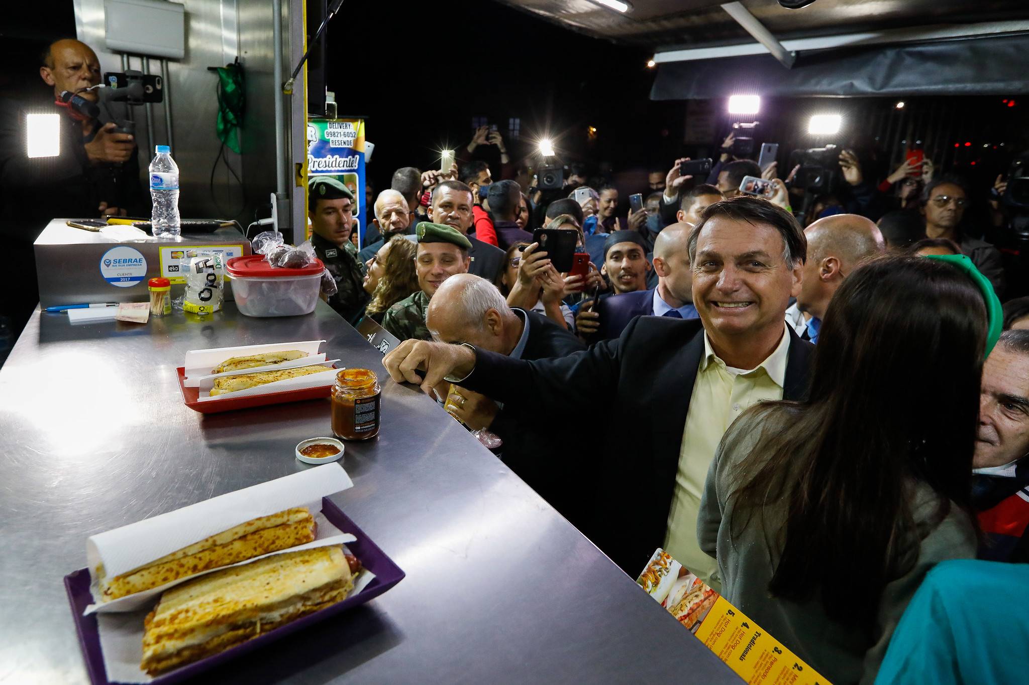 Presidente Jair Bolsonaro para para comer cachorro quente durante vista à Academia Militar das Agulhas Negras, em Resende (RJ), na quarta-feira (23).