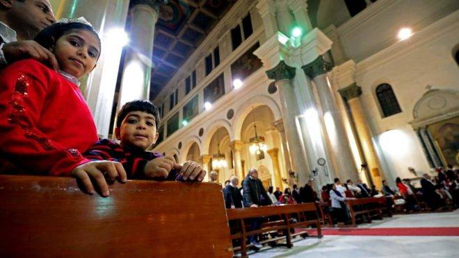 Crianças assistem enquanto os fiéis participam da missa da meia-noite na véspera de Natal na Igreja Católica Romana de São José, na capital egípcia Cairo, no distrito central da cidade, em 24 de dezembro de 2019: Egito é um dos países onde os cristão são mais perseguidos por causa de sua fé
