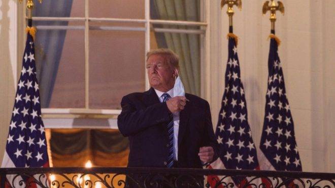O presidente americano Donald Trump retira a sua máscara ao chegar na Casa Branca, depois de ser liberado do hospital militar Walter Reed, onde estava para tratamento de Covid-19, 5 de outubro