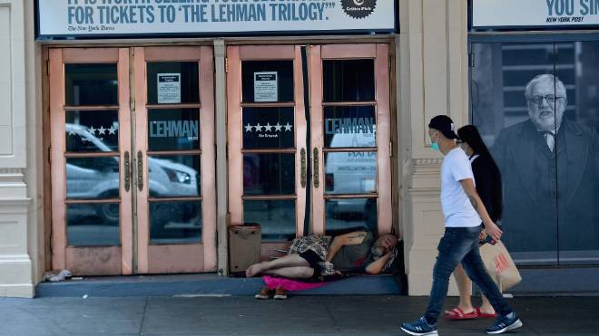 Desabrigado dorme em frente a um teatro fechado na Broadway, em Nova York.