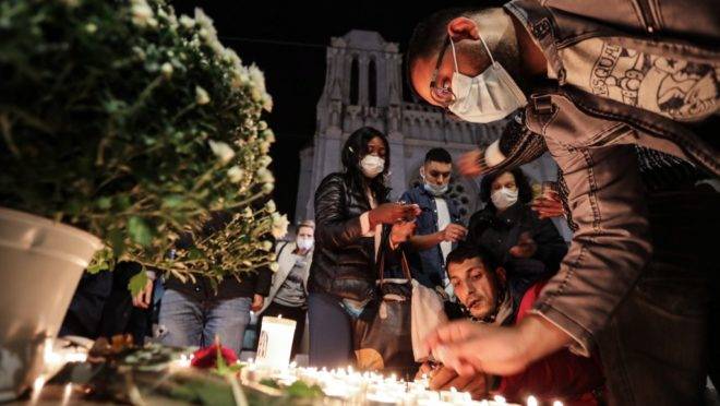 Pessoas fazem homenagens às vítimas de atentado em frente à Basília de Notre-Dame em Nice, França, 29 de outubro