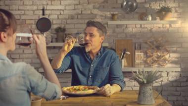 Aprenda a harmonizar vinhos com sua comida preferida Casal bebe vinho na mesa de jantar.