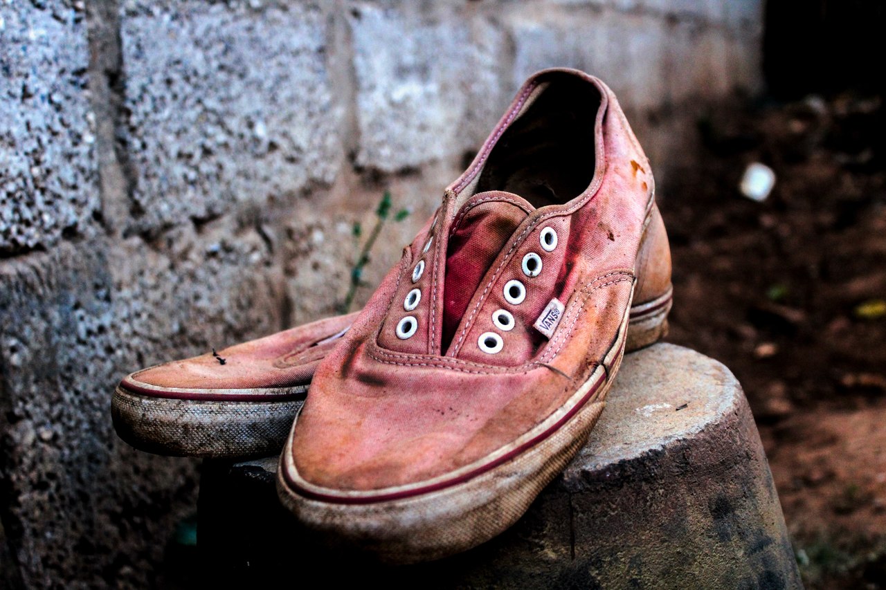 Borrifar álcool 70% em um sapato ou superfície sujos diminui a eficácia de desinfecção. Ideal é realizar antes a limpeza com água e sabão. Foto: Dickens Sikazwe/Unsplash. Borrifar álcool 70% em um sapato ou superfície sujos diminui a eficácia de desinfecção. Ideal é realizar antes a limpeza com água e sabão. Foto: Dickens Sikazwe/Unsplash.