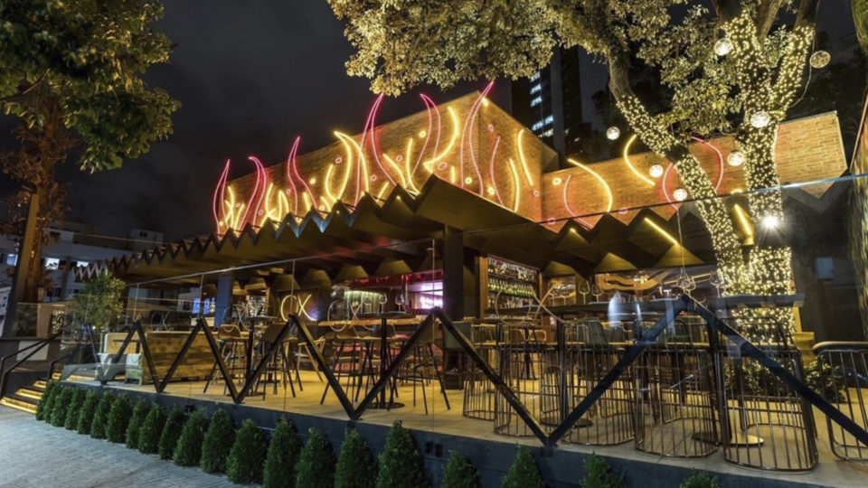 A iluminação externa é feita com fitas de neon e remete à sensação de brasas brilhantes e lava vulcânica
