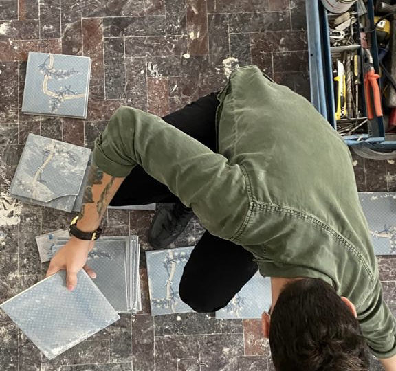 Tendência ou modismo? Por que novos compradores estão preferindo imóveis antigos Homem com azulejos e elementos de reforma em chão de apartamento.