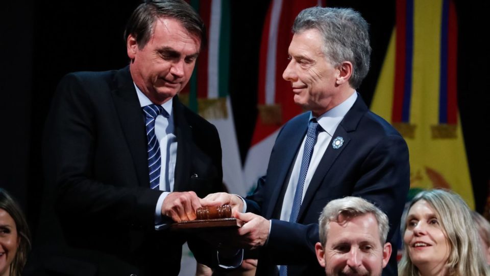 Os 30 anos do Mercosul O então presidente da Argentina, Maurício Macri, passa o posto de presidente pro tempore (cargo rotativo) do Mercosul ao presidente do Brasil, Jair Bolsonaro, durante a 54.ª Cúpula de Chefes de Estado do Mercosul, em julho de 2019.