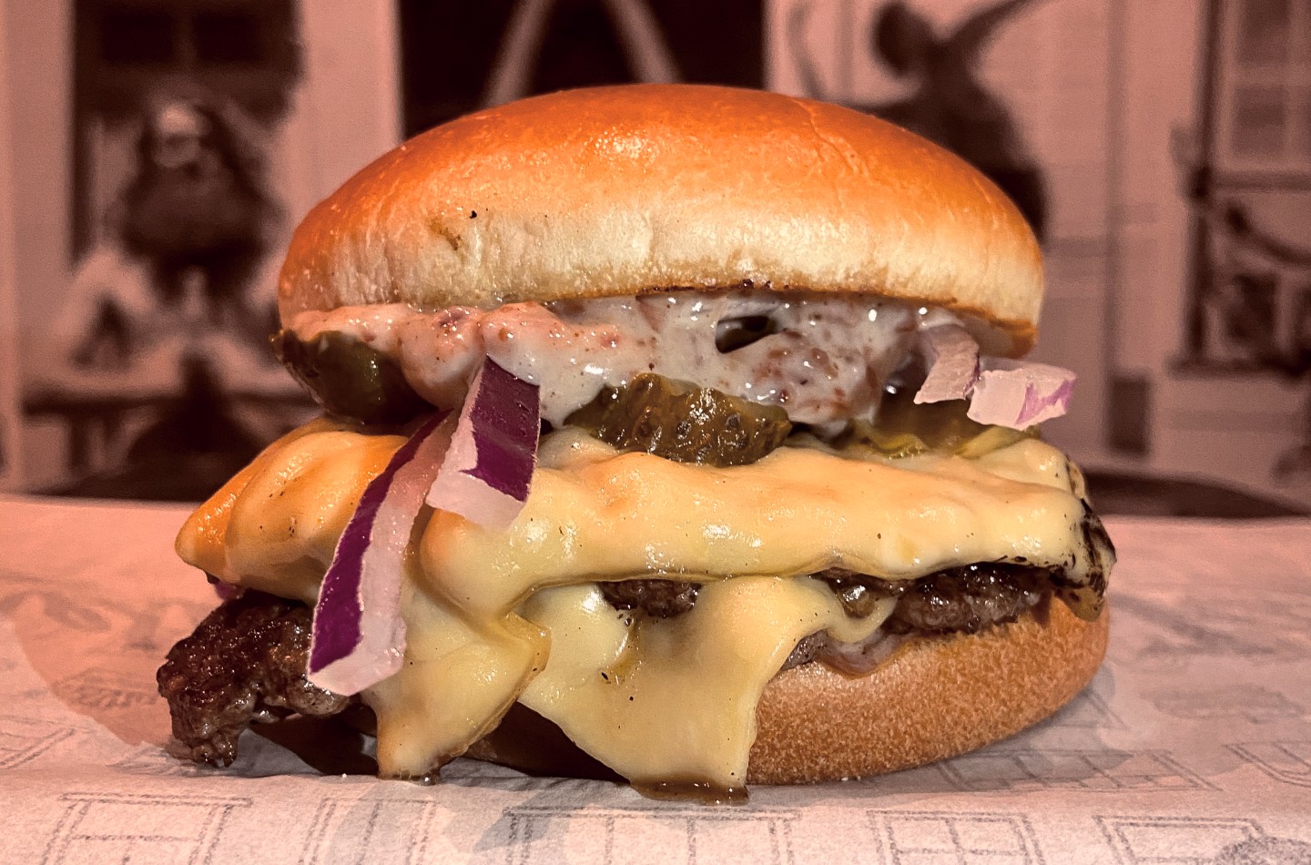 JanePicles, do Janela Bar, é feito com brioche, dois smash burgers, queijo prato, cebola roxa, picles e maionese de bacon.