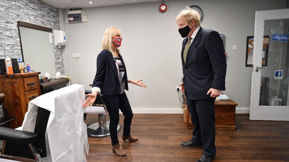 Britânicos voltam a pubs e lojas, e Boris Johnson corta o cabelo O primeiro-ministro britânico, Boris Johnson, usando uma cobertura facial, visita a Lemonheads Barber shop dentro do Lemon Street Market em Truro, Cornwall, sudoeste da Inglaterra em 7 de abril de 2021.