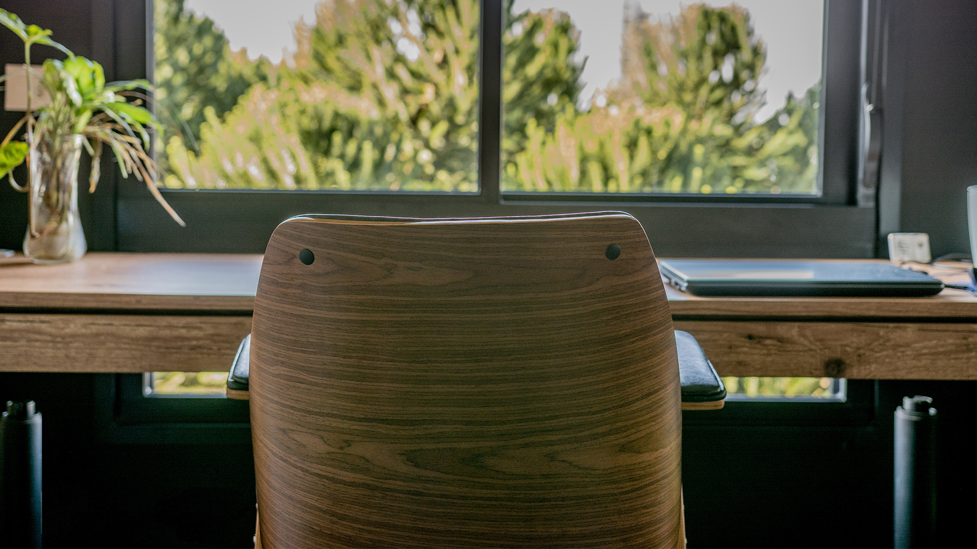 Neste home office a relação com as visuais é tratada como destaque, assim o enquadramento da paisagem se torna praticamente uma pintura de fundo