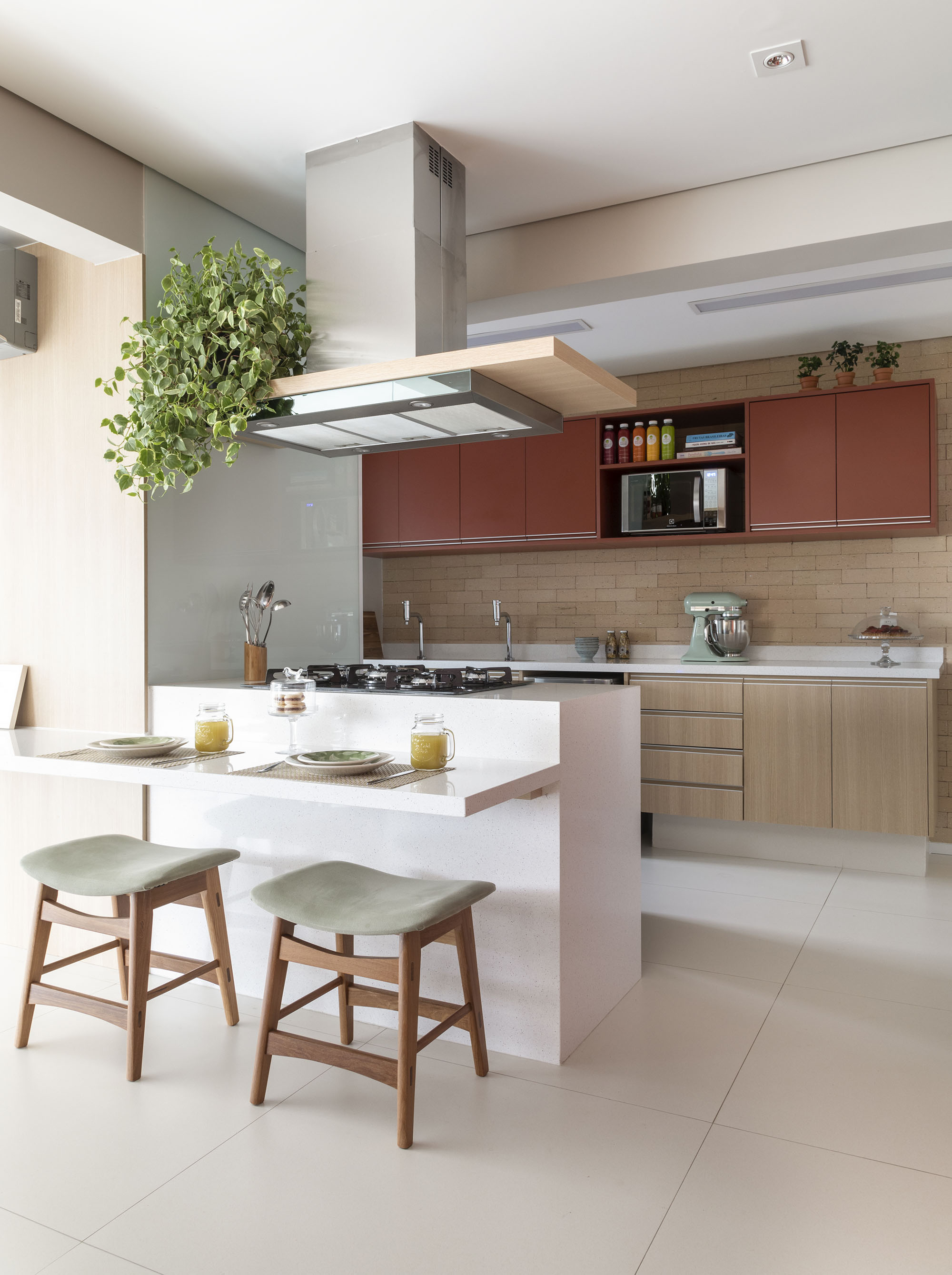 Cooktop foi instalado na península branca para liberar espaço na área do tampo e permitir que o cozinheiro fique de frente para as visitas. Para aproveitar melhor o espaço, uma bancada também foi integrada à península — solução funcional é ideal para refeições rápidas, como o café da manhã. Cooktop foi instalado na península branca para liberar espaço na área do tampo e permitir que o cozinheiro fique de frente para as visitas. Para aproveitar melhor o espaço, uma bancada também foi integrada à península — solução funcional é ideal para refeições rápidas, como o café da manhã.
