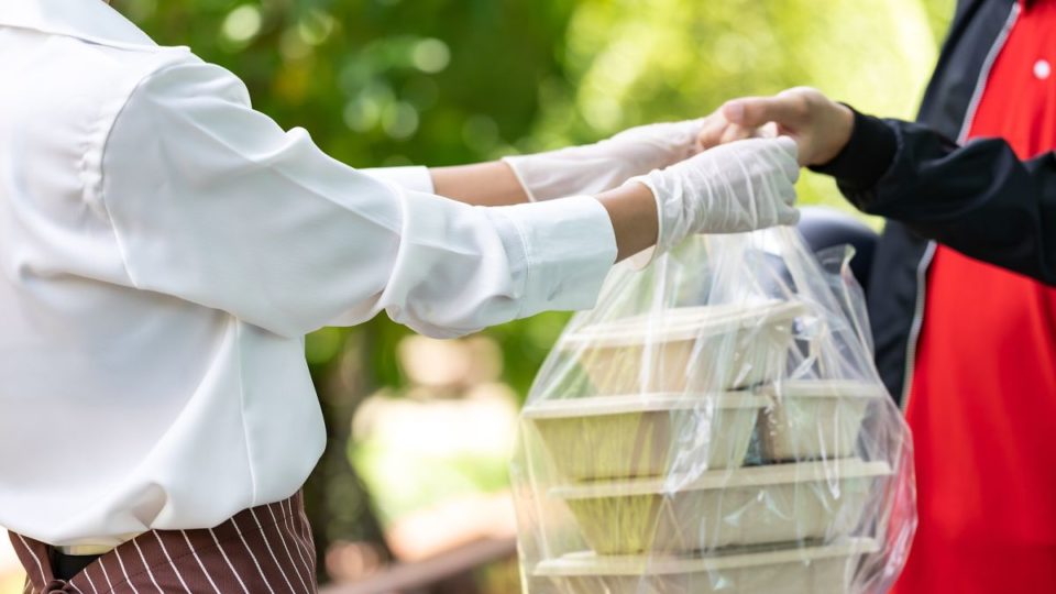 Solução de logística reversa da Turtle Box é finalista em laboratório global de inovação Close up waitress hand give food box to deliverly man to deliver it to customer make online order. Food deliverly service concept in new normal after coronavirus pandemic.