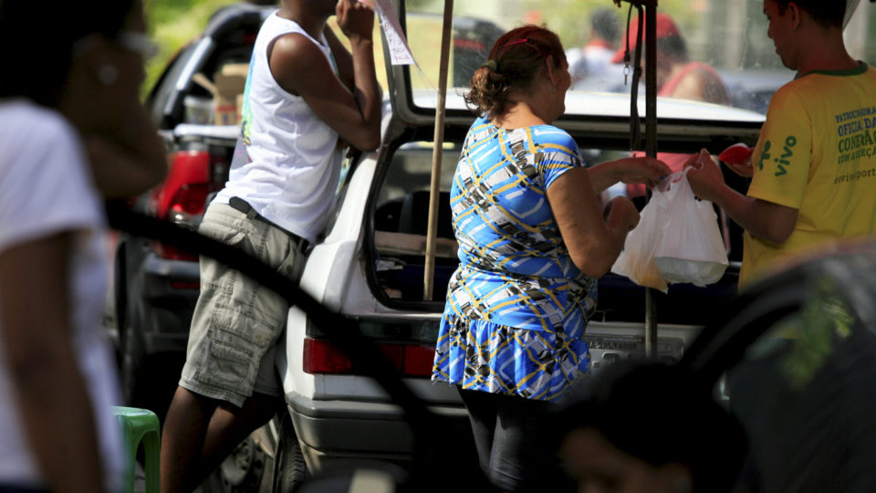 30 milhões de brasileiros recebem até um salário mínimo, aponta levantamento Pessoas vendem comida perto de veículos em Salvador.
