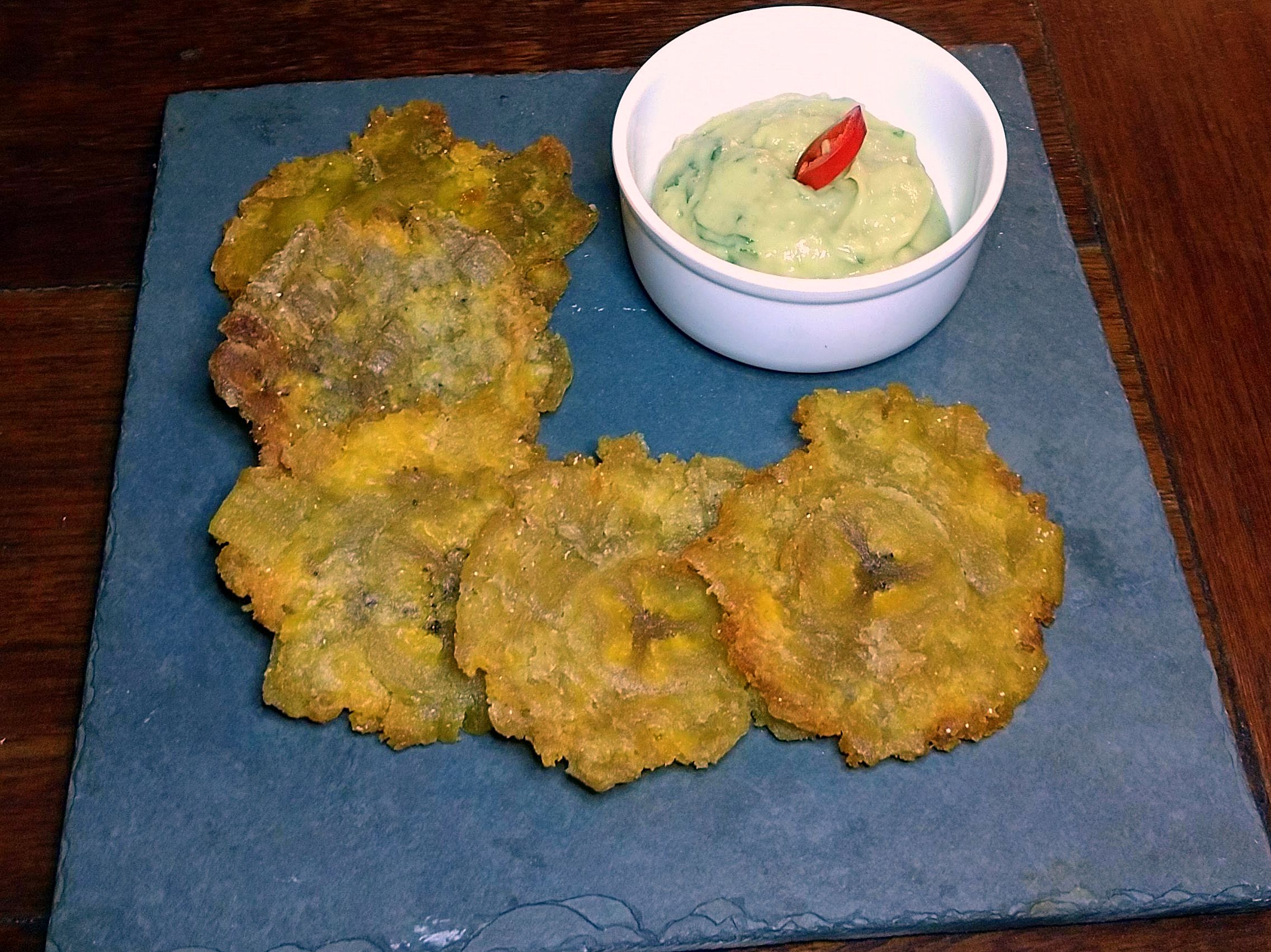 Patacones, medalhões prensados de banana-da-terra chips, acompanhados de guacamole Patacones, medalhões prensados de banana-da-terra chips, acompanhados de guacamole