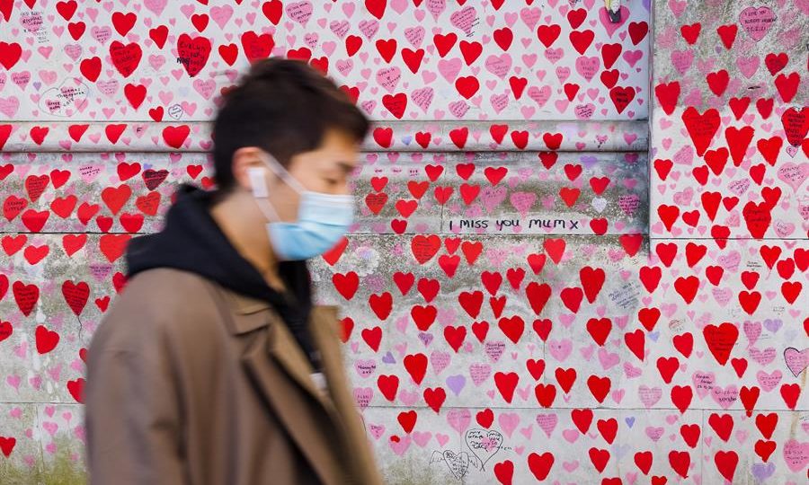 Afinal, as máscaras ajudaram a nos proteger durante a pandemia? Um homem usando máscara passa pelo National Covid Memorial Wall, uma homenagem àqueles que morreram por Covid-19, em Londres, Grã-Bretanha