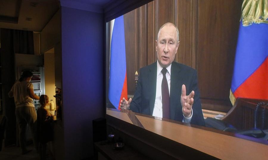 Família russa assiste ao presidente Vladimir Putin na TV