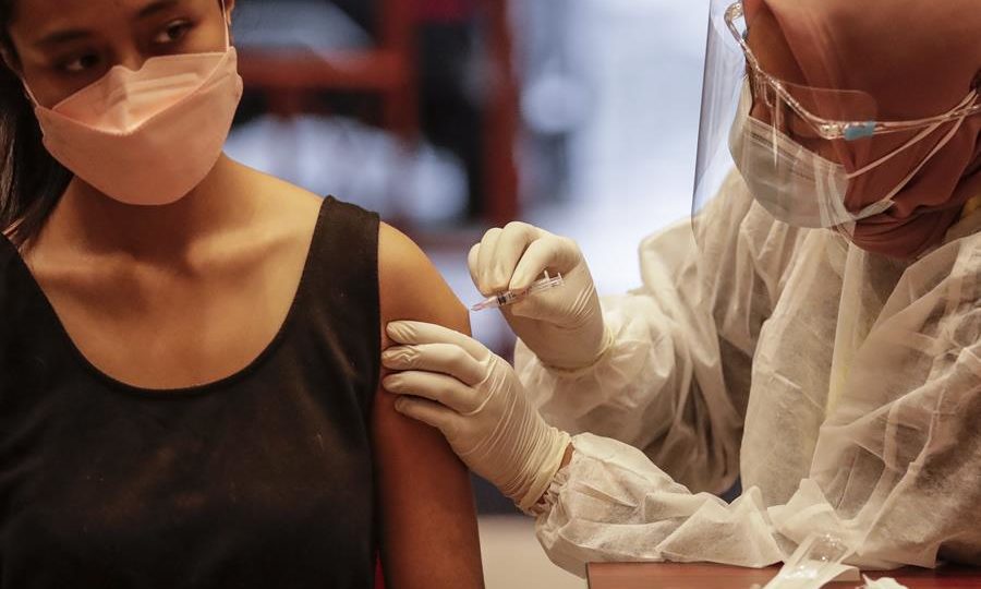 Narrativa contra eficácia da imunidade natural está ruindo com novos estudos Mulher recebe uma injeção de vacina de reforço Pfizer Covid-19 durante uma campanha de vacinação em Jacarta, Indonésia, 18 de janeiro de 2022: imunidade natural pode oferecer proteção tão boa ou até maior que a vacina