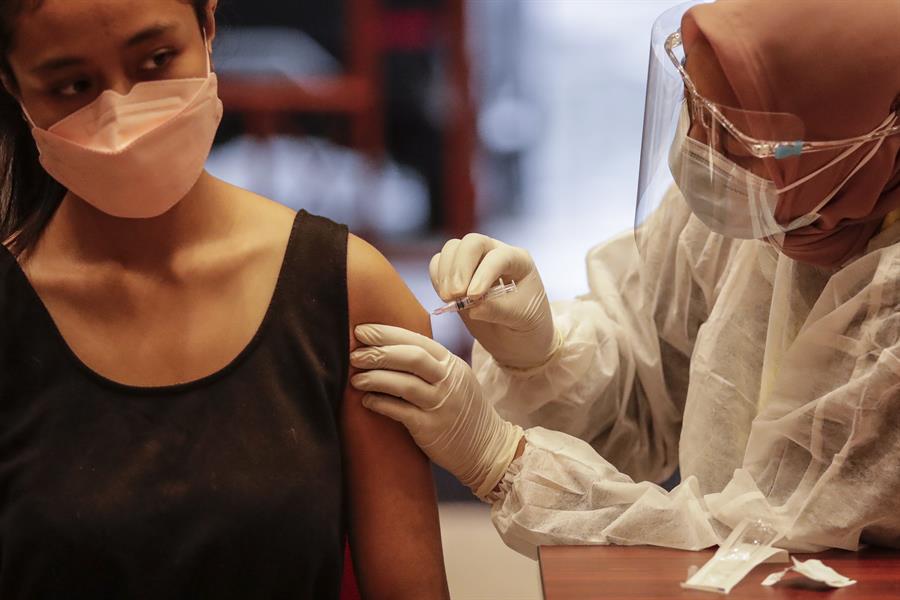 Mulher recebe uma injeção de vacina de reforço Pfizer Covid-19 durante uma campanha de vacinação em Jacarta, Indonésia, 18 de janeiro de 2022: imunidade natural pode oferecer proteção tão boa ou até maior que a vacina