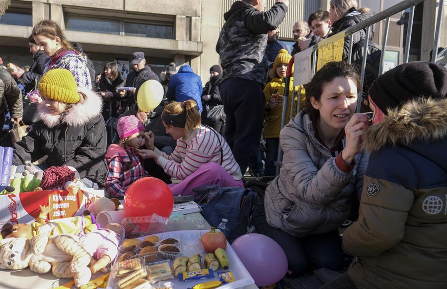 Pessoas esperam do lado de fora de um escritório de imigração na Bélgica, nesta quinta, depois de fugir da Ucrânia