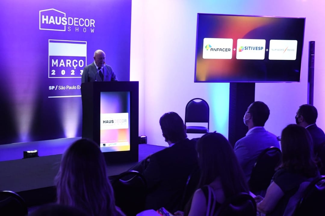 Evento de anúncio do Haus Decor Show. Um homem no palco fala para uma plateia. Evento de anúncio do Haus Decor Show. Um homem no palco fala para uma plateia.