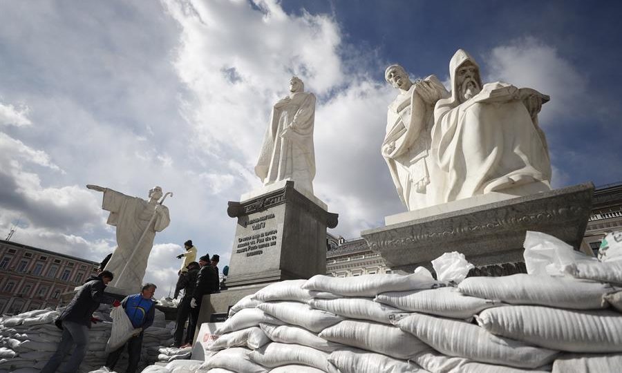 Voluntários colocam sacos de areia em monumento em Kiev, para protegê-lo de bombardeios russos, neste domingo