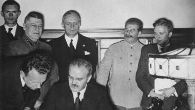 As convergências entre o nacional-socialismo e o comunismo soviético Stalin (em pé, de roupas claras) participa da assinatura do pacto Molotov-Ribbentrop, de não agressão com as forças nazistas, em 1939.