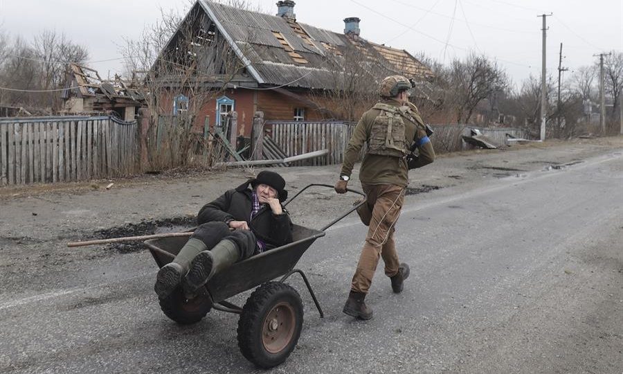 Militar ucraniano evacua idoso que teve sua casa danificada na vila de Teteriv, perto de Kiev