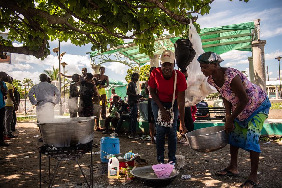 Haitianas cozinhando em uma praça, nesta semana, após fugir de confrontos de gangues