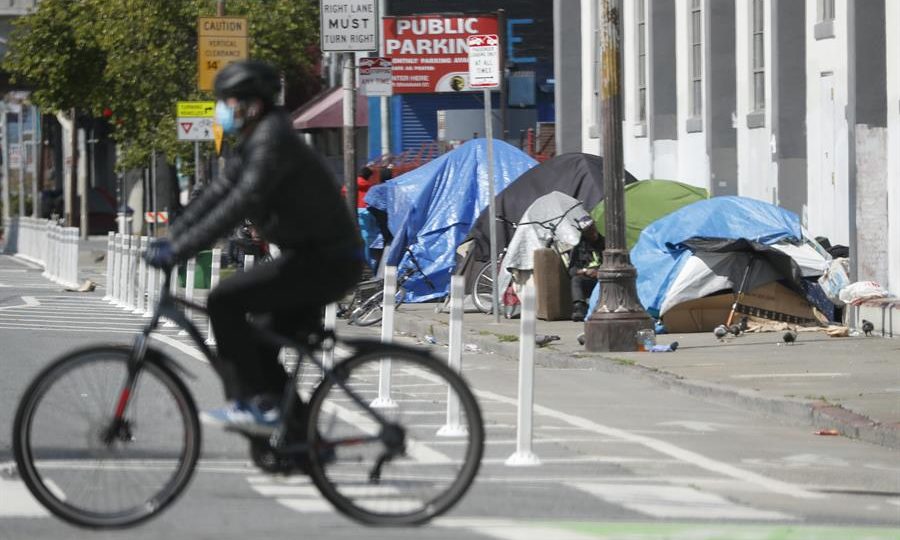 “Minha Casa, Meu Pesadelo”: o programa de moradia para viciados em São Francisco Ciclista passa por acampamento de pessoas sem-teto em uma calçada de São Francisco, Califórnia.
